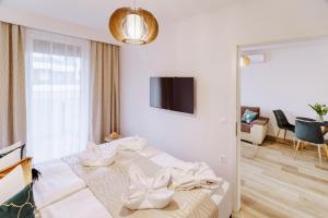 een slaapkamer met een bed en een woonkamer bij Alexandra Apartman in Keszthely