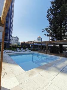 Una piscina con sillas y un edificio. en ITALIFOREST1203, en Punta del Este