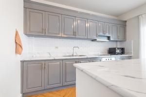 a kitchen with gray cabinets and a white counter top at Cliff & Beach Villa Phayun in Ban Phayun