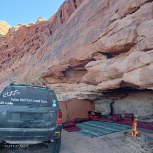 a truck parked in front of a rock cliff at golden day in Wadi Rum
