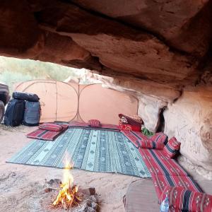 a tent with a fire in front of it at golden day in Wadi Rum