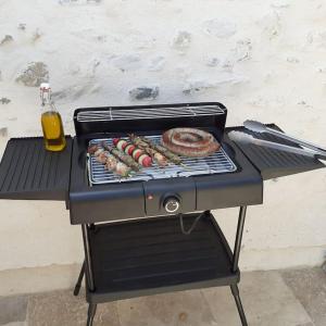 a grill with sausage and sausages on it at Maison Centre Historique Bize Minervois + Terrasse in Bize-Minervois