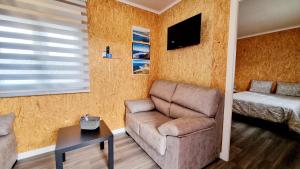 un soggiorno con un divano e una poltrona di Family Surf Home - Bungalow 4 a Santo Isidoro