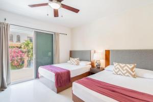 two beds in a room with a window at Comfortable Department Playa del Carmen in Playa del Carmen +9 photos