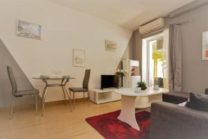 羅維尼的住宿－Apartman Den,Rovinj oaza u centru grada，客厅配有沙发和桌子