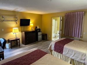 um quarto de hotel com duas camas e uma televisão de ecrã plano em Wye Motel em Clinton