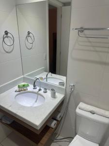 a bathroom with a sink and a toilet and a mirror at Rio Stay Residence in Rio de Janeiro