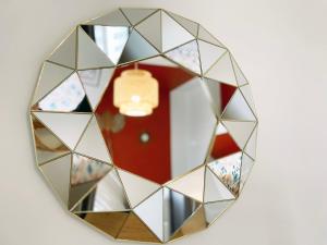 um espelho com um reflexo de uma porta vermelha em L'alcôve - Parking, Calme, Terrasse em Castres