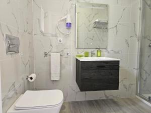 伊利亞沃的住宿－Curtido House Suits，白色的浴室设有卫生间和水槽。