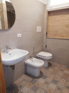 a bathroom with a sink and a toilet and a mirror at Villetta sullo Scoglio in Gela +41 photos