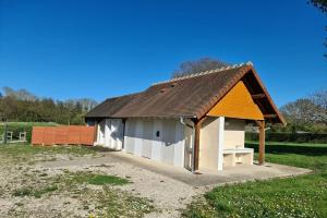 mały dom z brązowym dachem na polu w obiekcie Camping Onlycamp La Potinière w mieście Écueillé