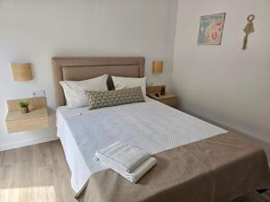 a bedroom with a bed with a towel on it at Curtido House Suits in Ílhavo