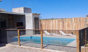 a house with a swimming pool and a fence at Sol montañes in La Carrodilla