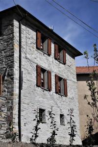 un antiguo edificio de piedra con ventanas de madera. en Antiche atmosfere... en Borzonasca
