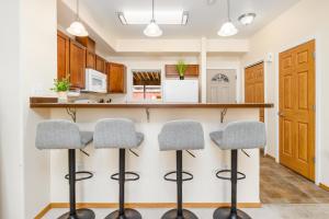 a kitchen with three bar stools in front of a counter at Harmony Hills #231 in Anchorage