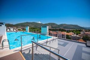 a large swimming pool with people in the water at Apartman EN in Trebinje