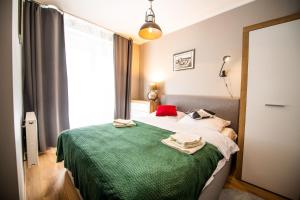 a bedroom with a bed with a green blanket at Apartament Miodowa 42 z miejscem parkingowym in Krakow