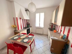 uma cozinha com uma mesa e cadeiras vermelhas em Appartamento Tipico Veneziano em Veneza