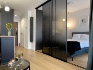 Cette chambre comprend un lit et une table avec des verres à vin. dans l'établissement URBAN APARTMENTS PREMIUM, Opolska 10 No 36, Free Garage, Self Check-in, à Katowice