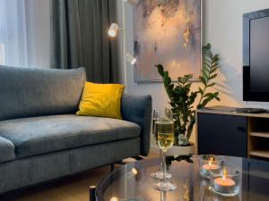 - un salon avec un canapé et une table avec des verres à vin dans l'établissement URBAN APARTMENTS PREMIUM, Opolska 10 No 36, Free Garage, Self Check-in, à Katowice