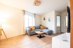 - un salon avec un canapé bleu et une table dans l'établissement Mulhouse by Hardt, à Mulhouse