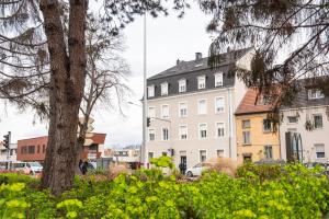 un gran edificio blanco junto a un árbol y edificios en Mulhouse by Hardt, en Mulhouse