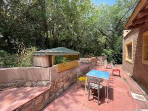 a patio with a table and chairs on a stone wall at Kasbah inn in La Cumbre