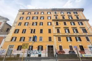 a tall yellow building with graffiti on it at Stylish Pigneto Apartment in Rome