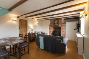 a living room with a table and a dining room at Rose Cottage in Burnham Thorpe
