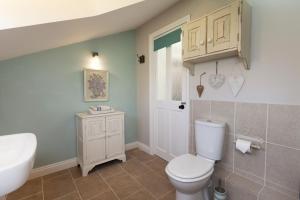 a bathroom with a white toilet and a sink at Rose Cottage in Burnham Thorpe +13 photos