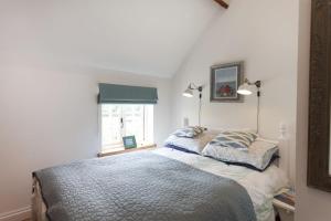 a bedroom with a bed and a window at Rose Cottage in Burnham Thorpe