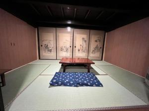 Yoshino-gun - House - Vacation STAY 90749v في Kami-ichi: طاولة في غرفة مع وسادة زرقاء على الأرض