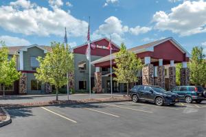 a hotel with cars parked in a parking lot at Best Western PLUS Victor Inn & Suites in Victor