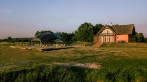 ein Haus mit einem Pavillon inmitten eines Feldes in der Unterkunft Svencelė Resort in Svenele