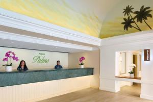a lobby with two people standing at the counter of a salon at Aqua Palms Waikiki in Honolulu