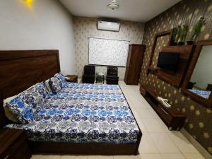 a bedroom with a bed and a television in it at Capital Lodge Gulistan-e-Johar in Karachi