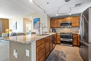 a kitchen with wooden cabinets and stainless steel appliances at Emerald Dolphin 0640 in Pensacola Beach
