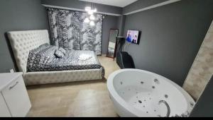 a bathroom with a bath tub and a bed at Apartmani 2 SS with jacuzzi bath in Ohrid
