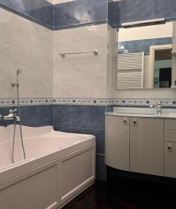 bagno con vasca, lavandino e specchio di Piazza Maggiore Luxury Apartment a Bologna