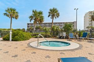 a small pool with palm trees and a building at Emerald Dolphin 0640 in Pensacola Beach