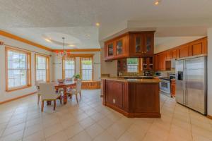 una cocina con armarios de madera y una mesa con sillas. en Grand Colony Island Villas, en San Pedro