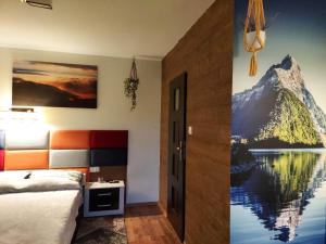 1 dormitorio con un mural de montaña en la pared en Apartament i pokoje u Roberta en Polańczyk