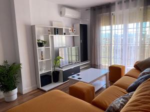 salon z kanapą i telewizorem w obiekcie Apartamento familiar Alhambra Granada w Grenadzie