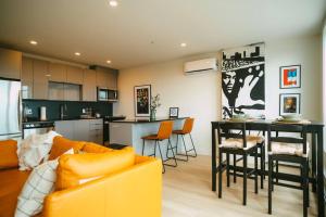 ein Wohnzimmer und eine Küche mit einem Sofa und einem Tisch in der Unterkunft *NEW* Stylish 2BR Condo with Views in North End in Halifax