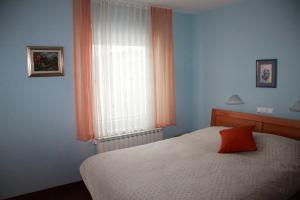sypialnia z łóżkiem i oknem z pomarańczową zasłoną w obiekcie Vila Krivec w Bledzie