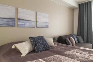 1 dormitorio con 1 cama y 3 cuadros en la pared en City Apartment Aapelintupa en Kuopio