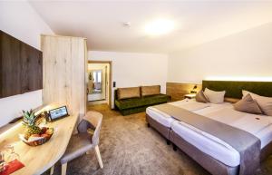 una camera d'albergo con un grande letto e una scrivania di Hotel Restaurant Schwörer a Lenzkirch