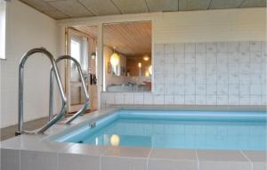 a bathroom with a swimming pool with two faucets at Beautiful Home In Ringkbing With 4 Bedrooms, Sauna And Wifi in Klegod