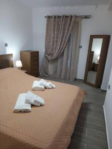 a bedroom with two towels on a bed at Dipotamata House SynetI in Andros
