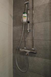 a shower in a bathroom with a shower head at City Apartment Aapelintupa in Kuopio